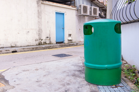 Green recycling bin container or garbage Trashcan on the street of city.の写真素材