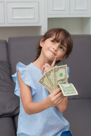 girl showing hundred dollar bills spread out like a fan isolated on white background.の写真素材