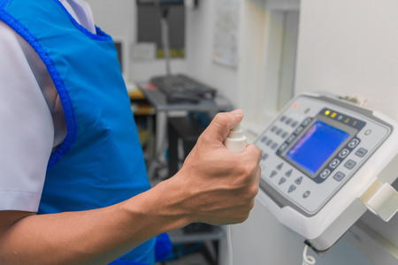 Hand pressing shutter switch control for x-ray at hospital.