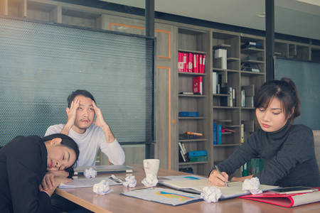Bored business people and sleeping resting on workplace during work meeting, concept of exhausted businesspeople bored sleep tired.の写真素材