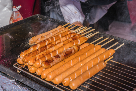 Pork sausages grilling on a portable BBQ at japan street food.の写真素材