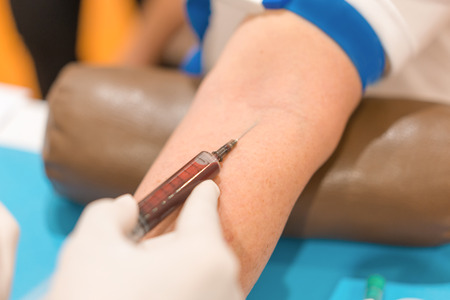 Nurse collecting a blood from patient in hospital.