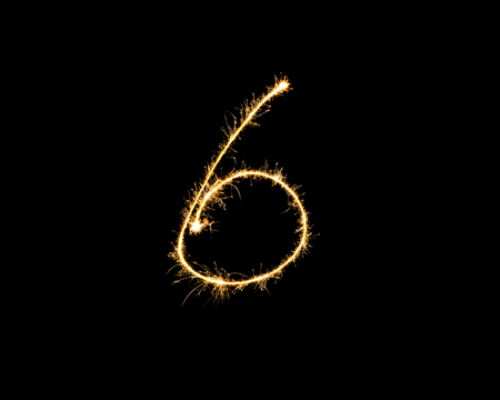 Numbers 6 or six Sparkler firework light isolated on black background.の写真素材