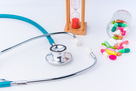stethoscope and drug pill with hourglass concept for doctor and medical nursing people check up healing of patients.の写真素材