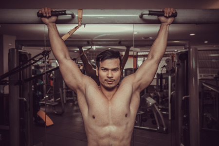 personal fitness trainer show his muscles or Strong bald bodybuilder with six pack.