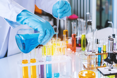 scientist with equipment and science experiments, laboratory glassware containing chemical liquid for research or analyzing a sample into test tube in laboratory.の写真素材