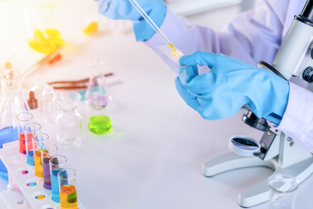 scientist with equipment and science experiments, laboratory glassware containing chemical liquid for research or analyzing a sample into test tube in laboratory.の写真素材