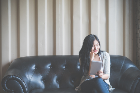 Portrait of woman reading a magazine online on tablet at coffee cafe.の写真素材