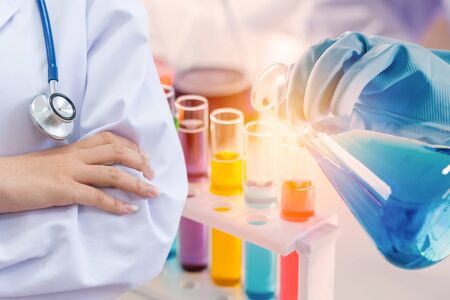 scientist with equipment and science experiments, laboratory glassware containing chemical liquid...