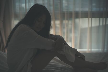 woman feel sad epressed and sitting in her bed.の写真素材