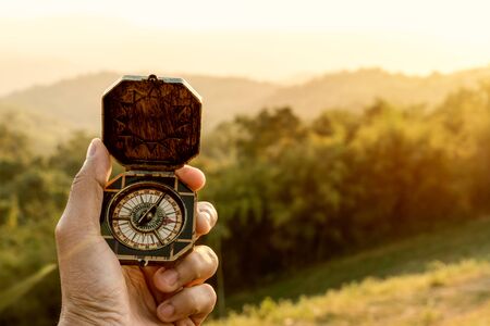 compass in man's hand with sunset nature background.の写真素材