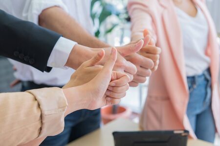 Successful business group with thumbs up in modern office.