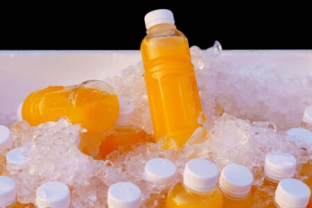 Orange juice bottles on ice box for healthy drink.の写真素材