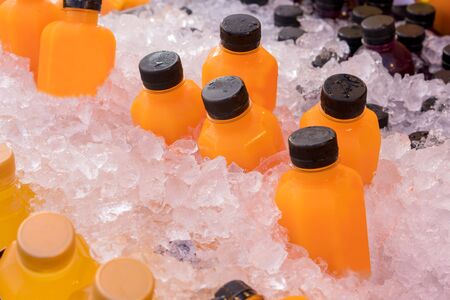 Orange juice bottles on ice box for healthy drink.の写真素材