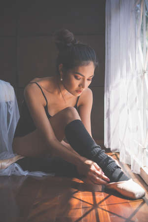 Beautiful young ballerina and pointe shoes is ballet dancers in room.の写真素材