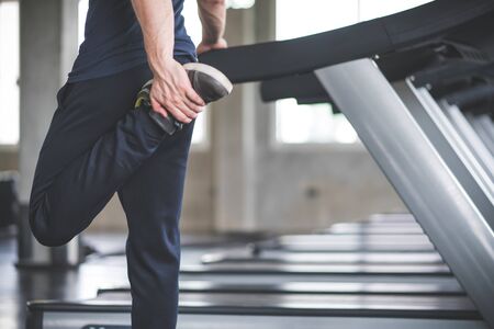 Handsome man warm up before exercise workout in gym fitness breaking relax for running on treadmill in fitness gym at sport club.の写真素材