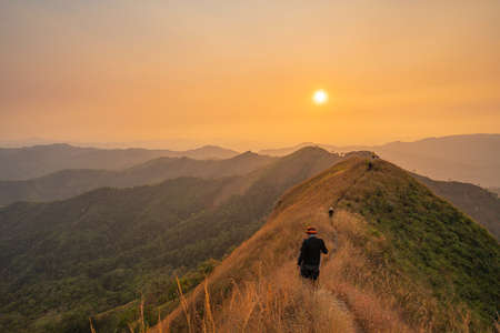 traveler man hiking enjoying in the mountains with backpack at Khao Chang Puak mountain Thailand.の写真素材