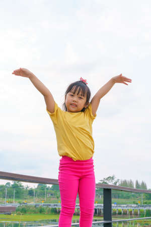 Little child girl Superhero in a gesture to fly on white background. Kid super hero concept.
