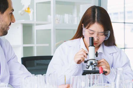 Doctor and microbiologist with vacuum tubes for samples with COVID 19 infection atypical pneumonia...