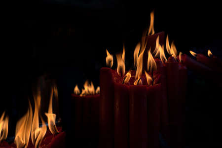 Burning candle on black background, Candle in the dark Design for the background. The light of the yellow stick candle in the dark at night.の写真素材