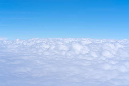 Blue sky and Clouds as seen through window of aircraftの写真素材