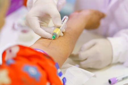 Nurse collecting a blood from patient in hospital.