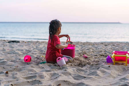 Child playing sand beach, on the beach on summer holidays. Children building a sandcastle at seaの写真素材