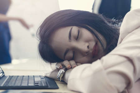 business woman work from home sleeping on the workplace and feel tired after working on tablet computer, Lifestyle woman relax after working at home concept. depressed businesswoman.の写真素材