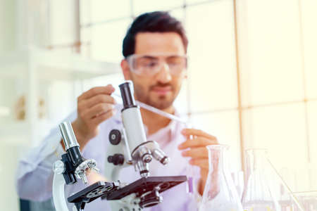 Doctor and microbiologist with vacuum tubes for samples with COVID 19 infection atypical pneumonia virus in laboratory.の写真素材