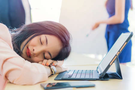 business woman work from home sleeping on the workplace and feel tired after working on tablet computer, Lifestyle woman relax after working at home concept. depressed businesswoman.の写真素材
