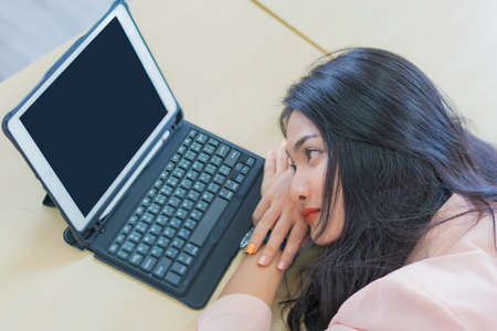 business woman work from home sleeping on the workplace and feel tired after working on tablet...