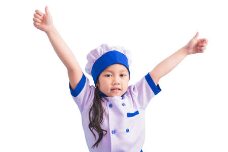 Happy girls with amazing smile in clothes and chef cap. child dreams of becoming a chef.の写真素材