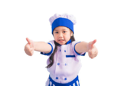 Happy girls with amazing smile in clothes and chef cap. child dreams of becoming a chef.の写真素材