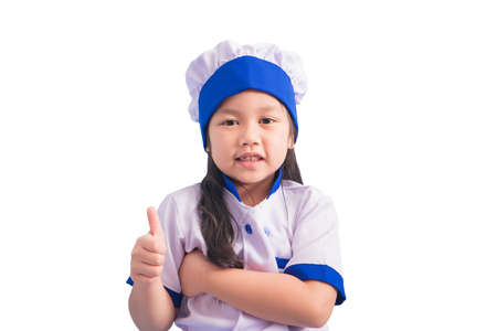 Happy girls with amazing smile in clothes and chef cap. child dreams of becoming a chef.の写真素材