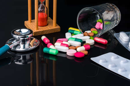 stethoscope and drug pill with hourglass concept for doctor and medical nursing people check up healing of patients.の写真素材