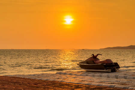 Jet ski parked on a beach with beautiful landscape sunset.の写真素材