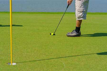 Golfer preparing for a putt Golf ball on the green during golfcourse.の写真素材