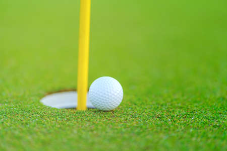 Golf ball on lip of cup at golf courtの写真素材