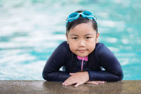happy children Smiling cute little girl in sunglasses in swimming pool.の写真素材