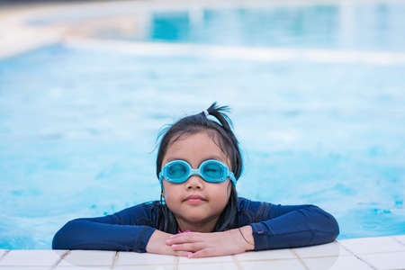happy children Smiling cute little girl in sunglasses in swimming pool.の写真素材