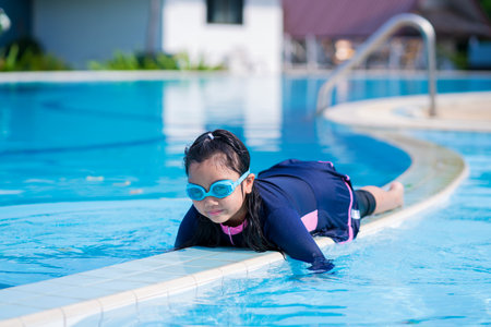 happy children Smiling cute little girl in sunglasses in swimming poolの写真素材