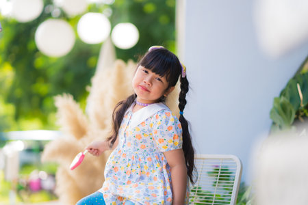 Cute smiling little girl eating an ice cream on a stick.の写真素材
