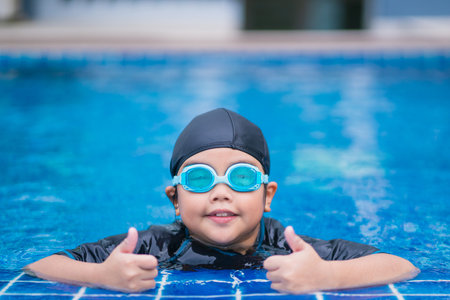 happy children Smiling cute little girl in sunglasses in swimming poolの写真素材