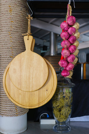 Garlic, onion and chilli, autumn season product, hanging on wooden logs in kitchen.の写真素材