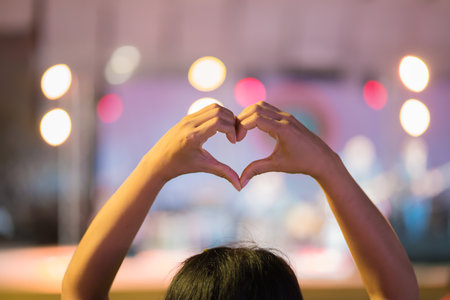 Woman hands of love heart-shaped hand gesture Concept of love, on stage with night party conceptの写真素材
