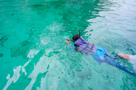girl in snorkeling mask swims among the fish in Koh Phi Phi Island Thailand, Pileh Lagoon.の写真素材