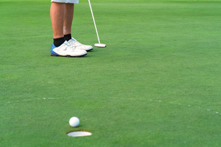 Golfer putt golf ball into hole on the green at golf course.の写真素材