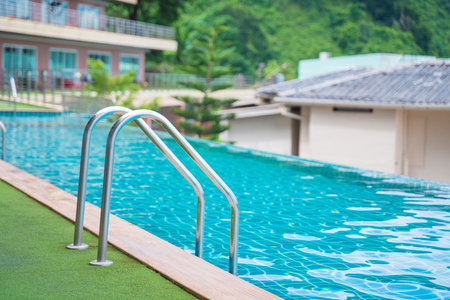 blue swimming pool at hotel with stairの写真素材