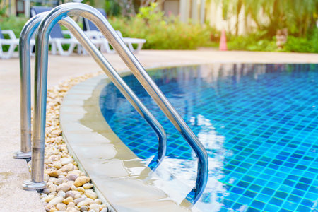 blue swimming pool at hotel with stairの写真素材