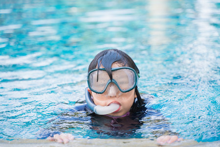 Young girl in pool with swimming mask and snorkel.の写真素材